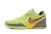 Side profile showing the orange Jumpman-style side branding, gray midsole sections, and yellow-green upper.