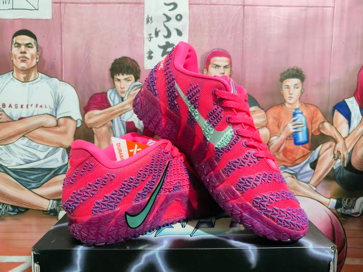 Pair of purple-red Nike basketball sneakers displayed on a black shoebox, showing the patterned upper, green swoosh, and translucent purple outsole.