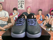 Front view of black Jordan basketball sneakers with purple laces, tongue branding, and contrasting soles.