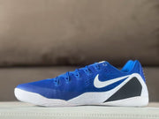 Side view highlighting the royal blue upper, white swoosh, black side panel, and white speckled midsole.