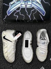 Top and underside views of the off-white and black sneakers beside the lightning-themed box.