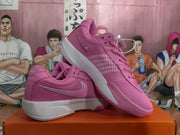 Angled view of pink Nike basketball sneakers showing the side swoosh, patterned side panel, and white midsoles.