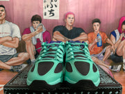 Front view of gray-green Nike sneakers showing layered panels, mint-green laces, and black mesh openings.