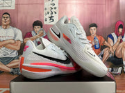 Angled view of white Nike basketball shoes with pink and orange details