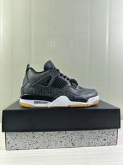 Side profile of a black Air Jordan 4 sneaker displayed on a speckled shoebox, showing tonal graphics, black cage detailing, white midsole accents, and a gum outsole.