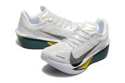 Pair of off-white Nike Zoom Fly 6 shoes with dark green midsoles and yellow accents