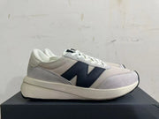 Side profile of a New Balance U370 sneaker in gray, off-white, and navy.