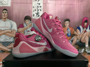 Pair of pink Nike basketball sneakers displayed on a black shoebox, showing the side swoosh, layered pink panels, and translucent-looking soles.