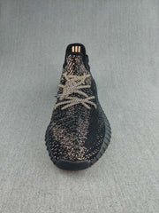 Top view of a black lace-up sneaker showing the patterned upper and rounded toe.