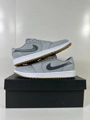 Pair of grey and blue Jordan low-top golf sneakers displayed on a black shoebox.