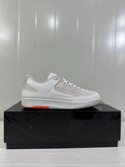 Single side profile of the light beige and white low-top sneaker on a black box.