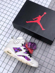Jordan shoe box and sneaker displayed together, with the white and purple color scheme visible.