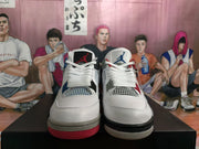 Front view of the white Jordan sneakers showing mesh panels, laces, and contrasting blue and red details.