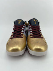 Front view of the pair showing perforated gold toe boxes and red-and-black laces.