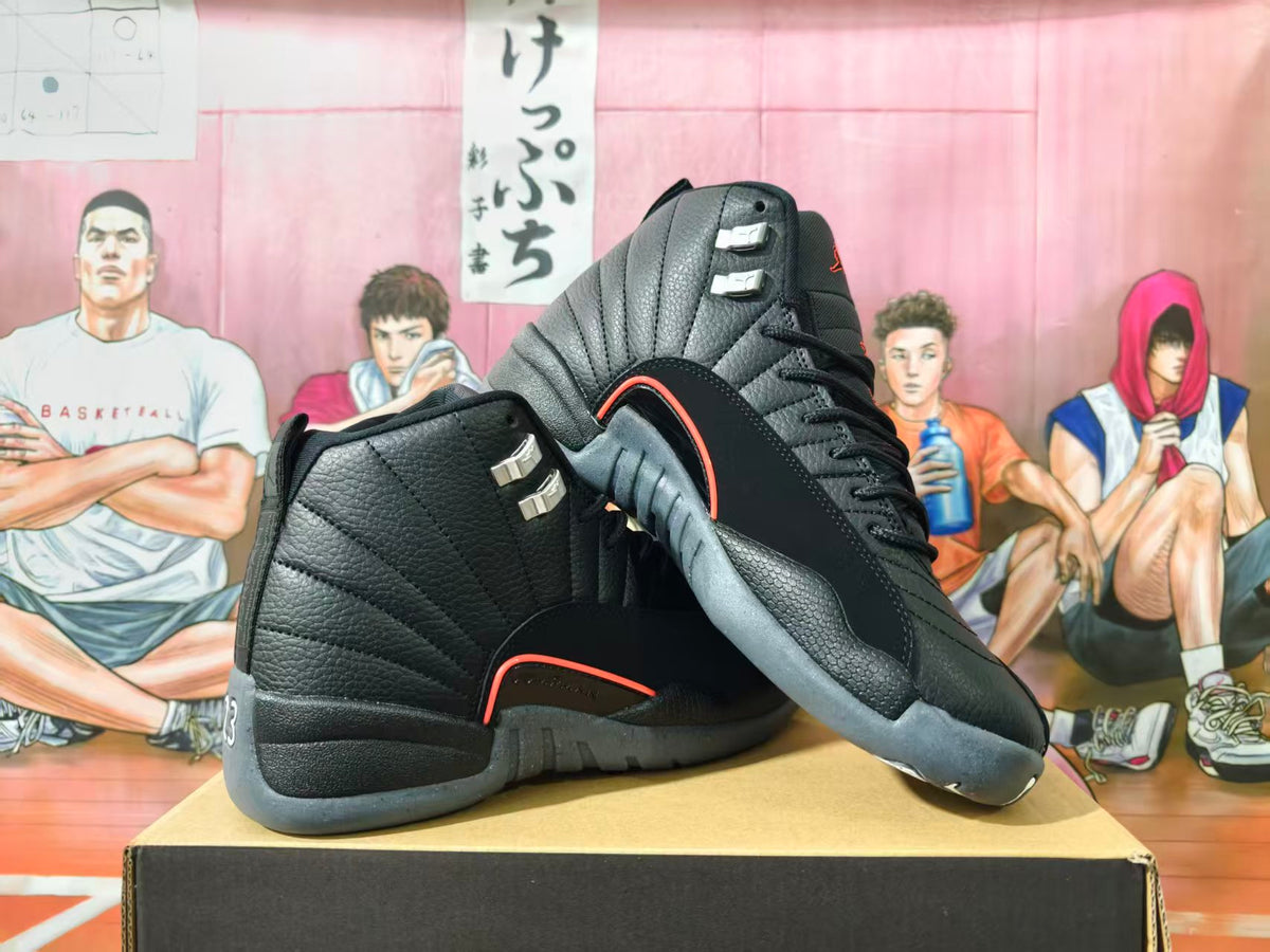 Pair of black high-top Jordan basketball sneakers with grey soles and orange trim, shown from the side and rear.