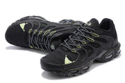 Angled top view of black Nike Air Max Plus sneakers with patterned laces