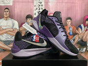Angled display of the black and purple Nike basketball sneakers showing both the side Swoosh and contrasting purple panels.